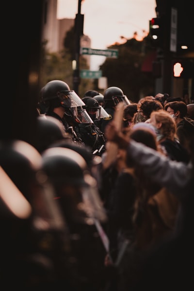 穿着黑色夹克和头盔的人们晚上站在街上